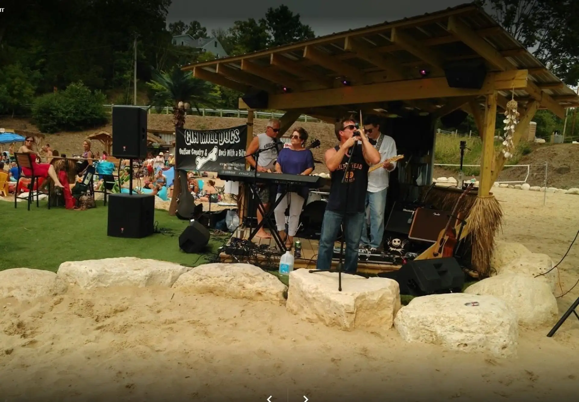 Band playing the thatched beach stage to a full crowd