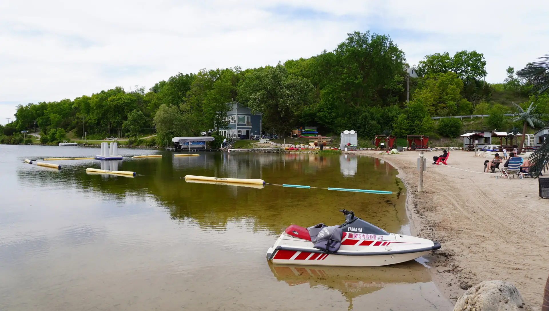 The roped swim area and beach with a personal watercraft pulled ashore